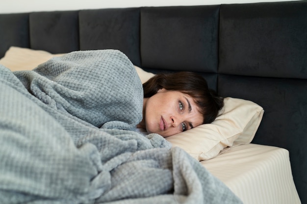 Tiro medio mujer enferma en la cama