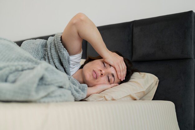 Tiro medio mujer enferma tendido en la cama