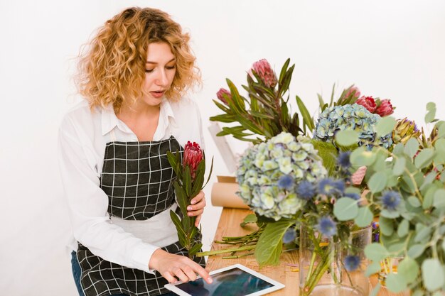 Tiro medio mujer escribiendo algo en tableta