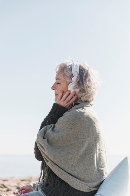 Tiro medio mujer escuchando música en la naturaleza