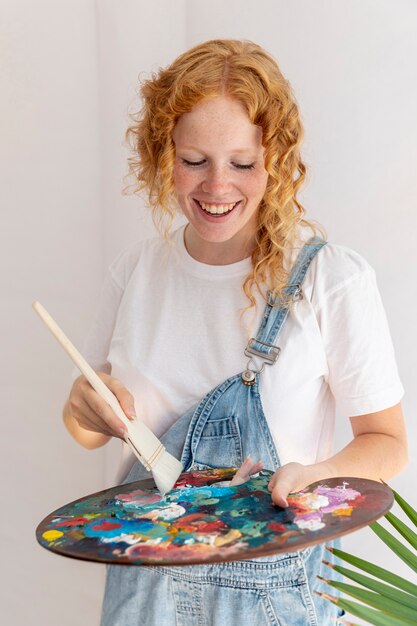 Tiro medio mujer feliz con paleta de pintura