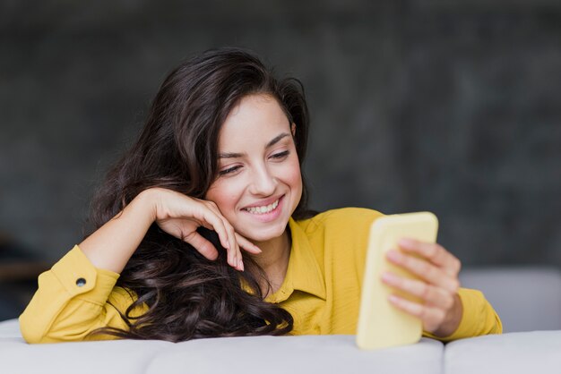 Tiro medio mujer feliz con teléfono móvil