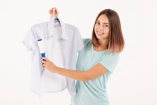 Tiro medio mujer feliz usando un rodillo de pelusa