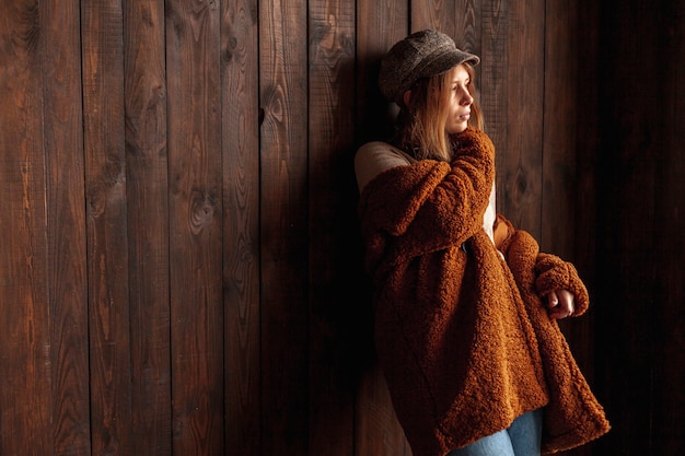 Tiro medio mujer con fondo de madera posando