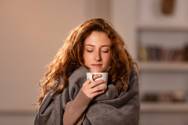 Tiro medio mujer fría con taza de té