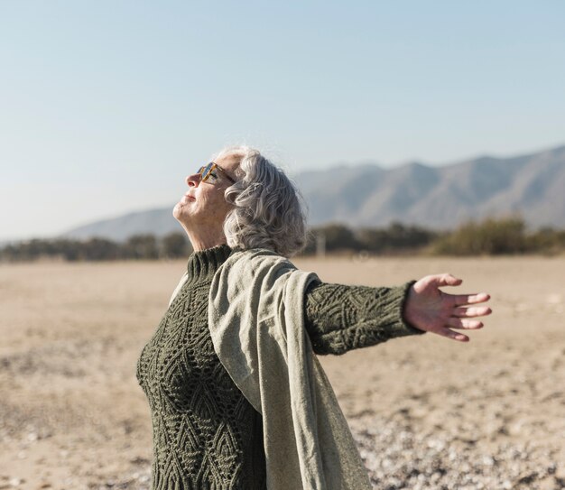 Tiro medio mujer con gafas de sol al aire libre