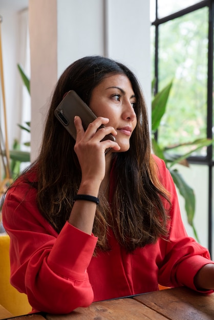 Foto gratuita tiro medio mujer hablando por teléfono