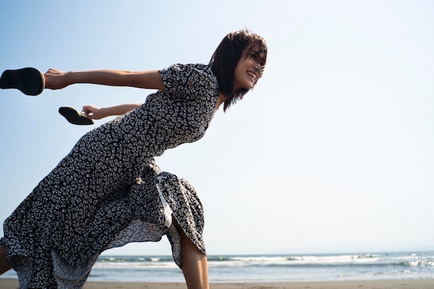 Foto gratuita tiro medio mujer japonesa corriendo en la playa