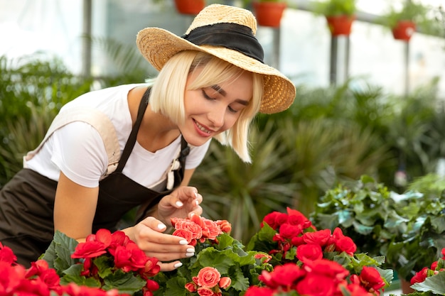 Foto gratuita tiro medio mujer mirando flores