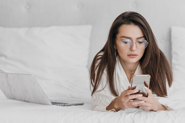 Tiro medio mujer mirando el teléfono