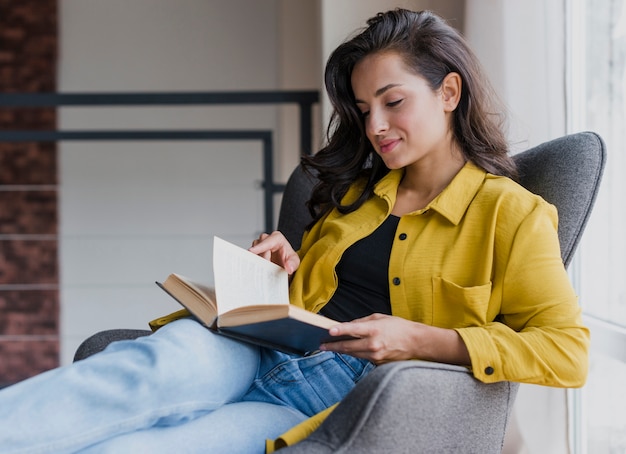 Foto gratuita tiro medio mujer morena en sillón