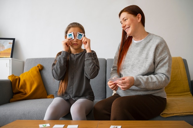 Foto gratuita tiro medio mujer y niña jugando juego de memoria