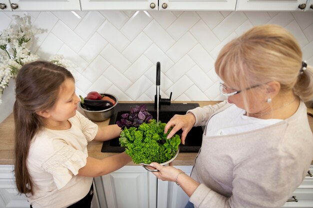 Tiro medio mujer y niña con lechuga