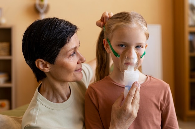 Foto gratuita tiro medio mujer y niña con nebulizador.