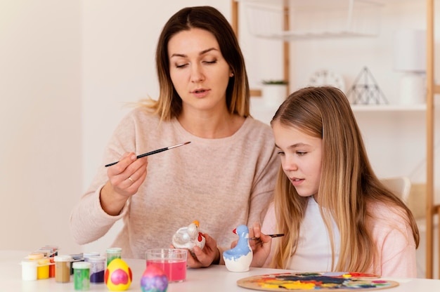 Tiro medio mujer y niña sosteniendo cepillos