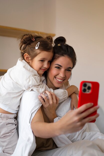 Tiro medio mujer y niña tomando selfie