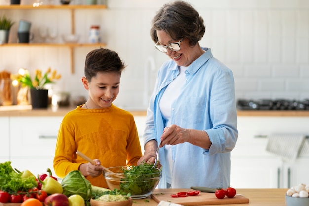 Tiro medio mujer y niño cocinando juntos