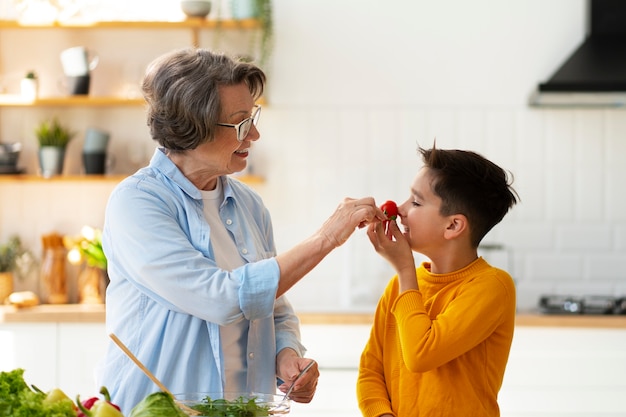 Foto gratuita tiro medio mujer y niño cocinando juntos