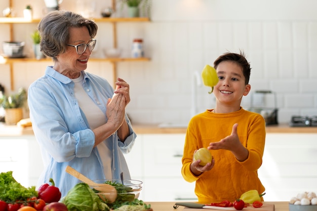 Foto gratuita tiro medio mujer y niño cocinando juntos