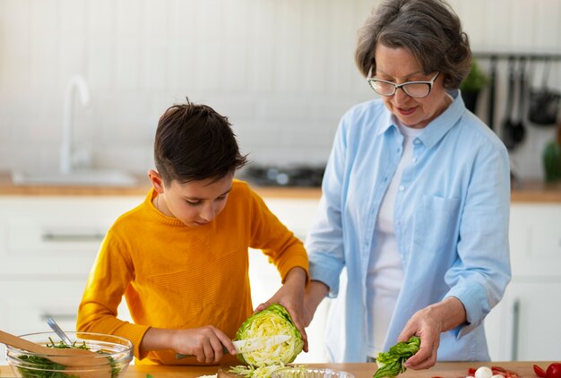 Foto gratuita tiro medio mujer y niño cocinando juntos