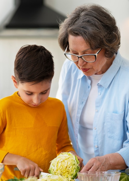 Tiro medio mujer y niño cocinando juntos