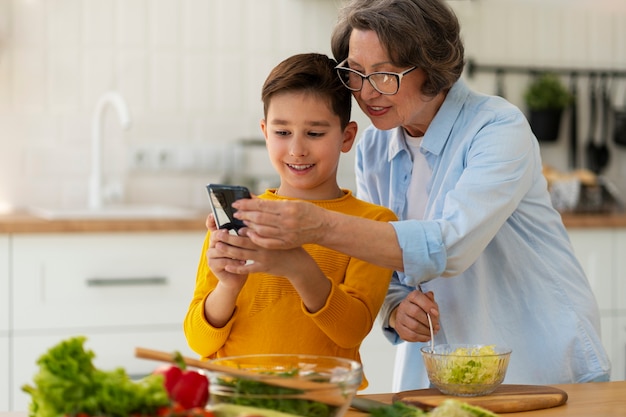 Foto gratuita tiro medio mujer y niño cocinando juntos