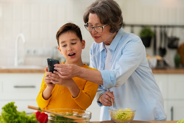 Tiro medio mujer y niño cocinando juntos