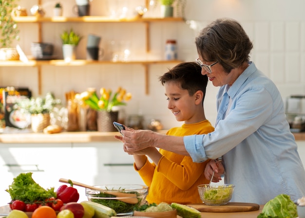 Foto gratuita tiro medio mujer y niño cocinando juntos