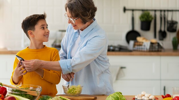 Tiro medio mujer y niño cocinando juntos