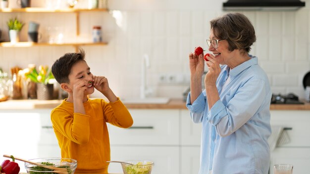 Tiro medio mujer y niño cocinando juntos