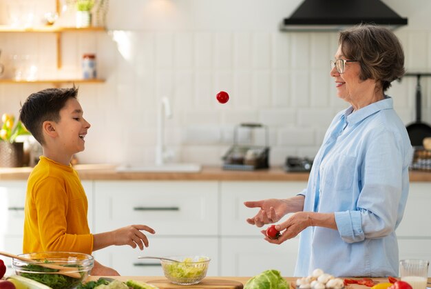 Tiro medio mujer y niño cocinando juntos