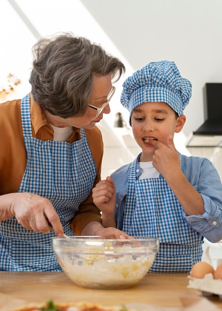 Tiro medio mujer y niño cocinando juntos