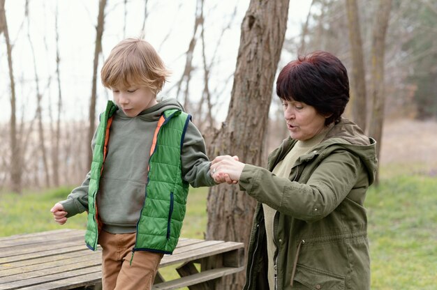 Tiro medio mujer y niño cogidos de la mano