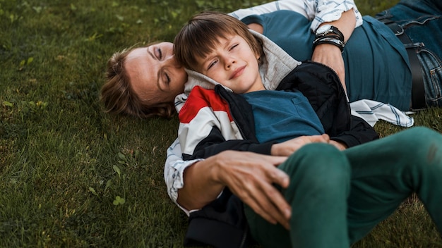 Foto gratuita tiro medio mujer y niño sobre el césped