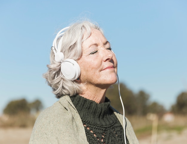 Foto gratuita tiro medio mujer con los ojos cerrados y auriculares