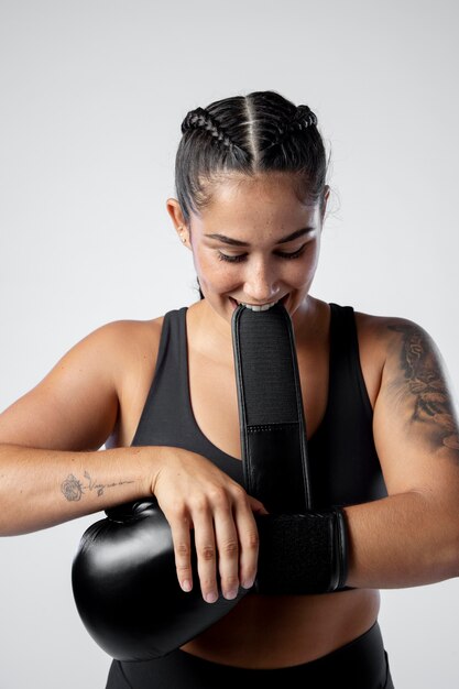 Tiro medio mujer poniéndose un guante de boxeo