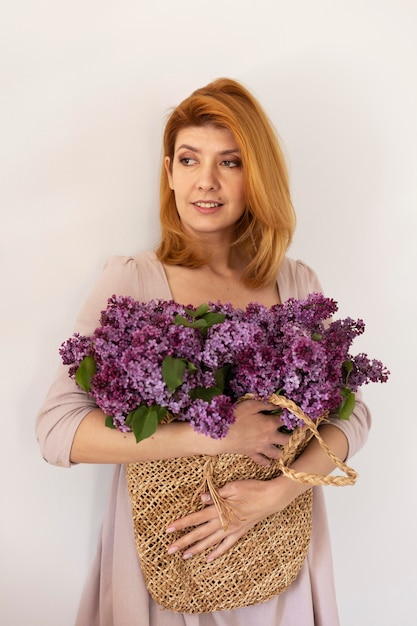 Tiro medio mujer posando con canasta de flores