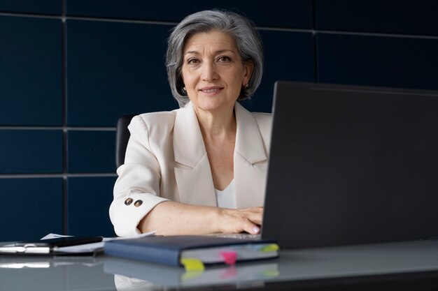 Tiro medio mujer que trabaja en la computadora portátil