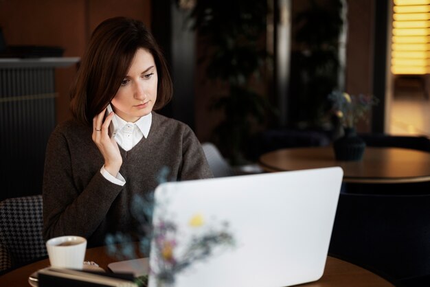 Tiro medio mujer que trabaja en la computadora portátil