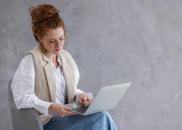 Tiro medio mujer que trabaja en la computadora portátil