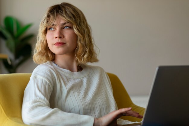 Tiro medio mujer que trabaja en la computadora portátil