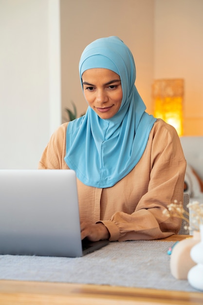 Foto gratuita tiro medio mujer que trabaja en la computadora portátil