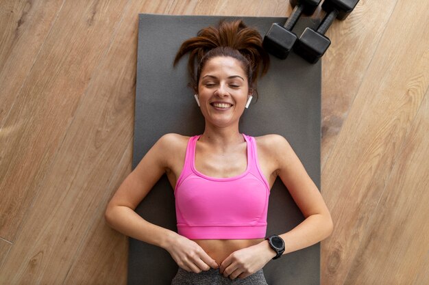 Tiro medio mujer recostada sobre estera de yoga