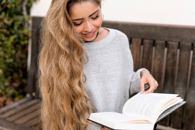 Foto gratuita tiro medio mujer rubia leyendo un libro