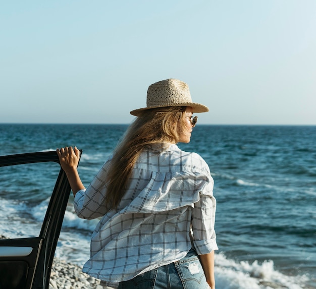 Foto gratuita tiro medio mujer rubia mirando al mar en coche