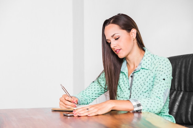 Foto gratuita tiro medio mujer sentada y escribiendo