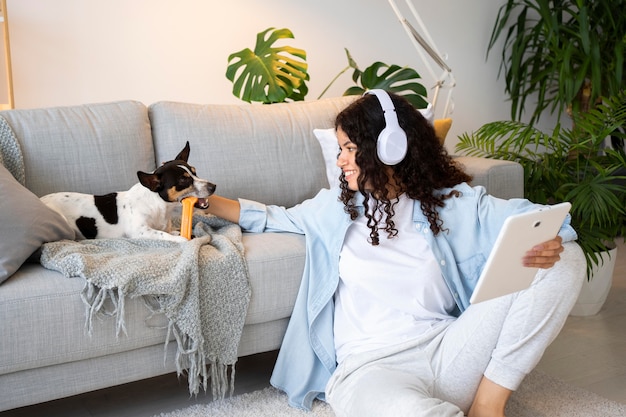 Foto gratuita tiro medio mujer sentada en el suelo con mascota