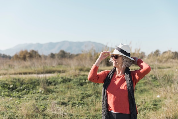 Foto gratuita tiro medio mujer con sombrero y gafas de sol