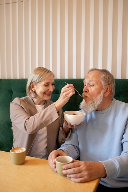 Tiro medio mujer sonriente alimentando a hombre