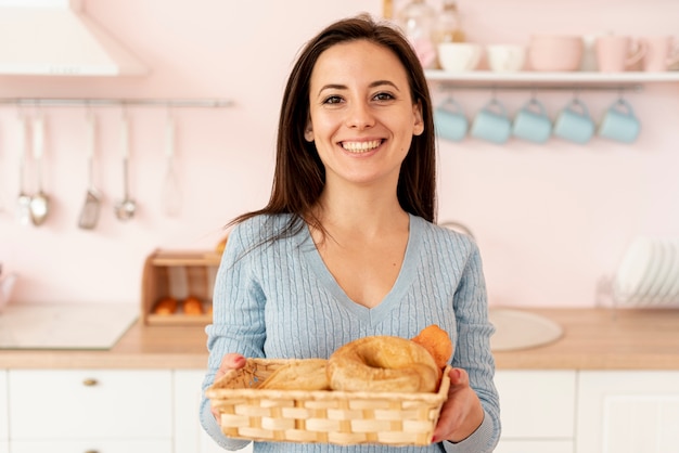 Tiro medio mujer sonriente con canasta de pasteles